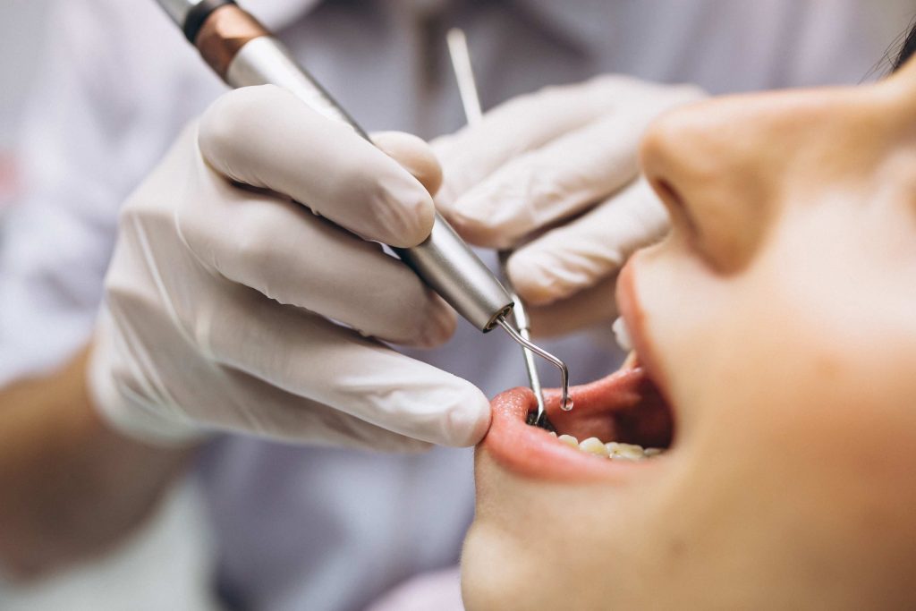 Woman getting her teeth cleaned by a dentist 